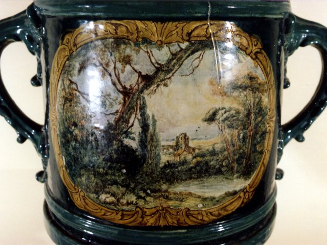 Grande vaso ornamentale - Grande vaso ornamentale in maiolica policroma con coperchio. Fondo verde. Particolare lato B.Scarica il file