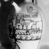 Vaso  - Vaso per olio con vista di ceramisti sui tetti delle botteghe grottagliesi. Opera di Roberto Rosati datata 1939.Scarica il file