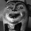Vaso  - Vaso a forma di viso paffuto sorridente, decorato a smalti.Scarica il file
